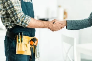 plomero dando la mano a un cliente